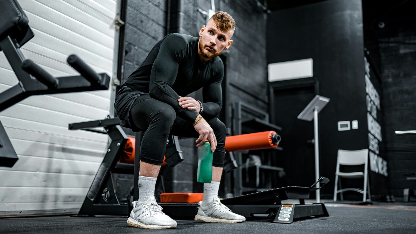 Athlète en récupération active effectuant un étirement isométrique de quadriceps avec bande élastique verte